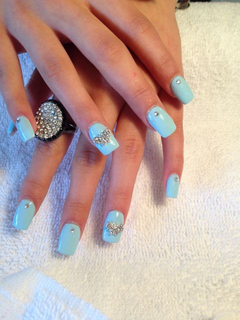 Light blue acrylic nails with rhinestone butterfly accents